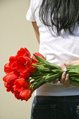 Girl with red tulips in handの写真素材