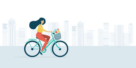 Woman riding bicycle with basket of flowers. Cityscape backgroundのイラスト素材