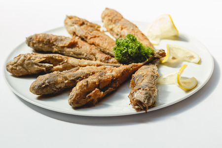 Fried fishes on white background for the menuの写真素材
