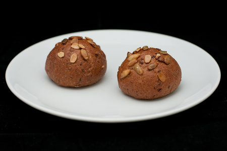 Two rye sandwich with pumpkin seeds buns on white plate