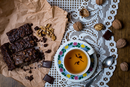 Cup of tea with cake chocolate brownies on served wooden table, top viewの写真素材