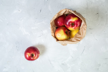 Apples in paper bag on gray background. Top view point.の写真素材