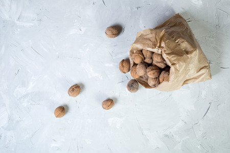 Walnuts in paper bag on gray background. Top view point.の写真素材