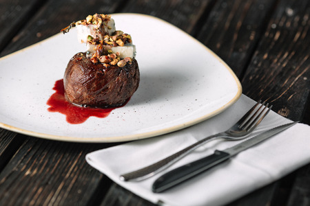 Tenderloin steak on irregular shape plate with gorgonzola on dark wood backgroundの写真素材