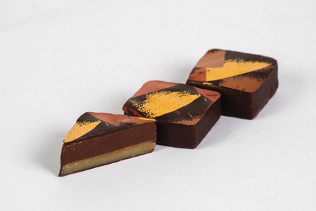 Cut handmade chocolate candy with filling isolated on whiteの写真素材