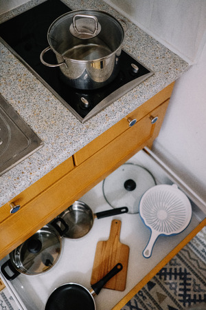 Pot on the stove and open box with kitchen utensilsの写真素材
