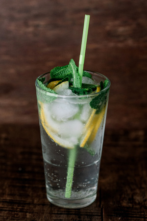 Glass of lemonade with ice on a wooden backgroundの写真素材