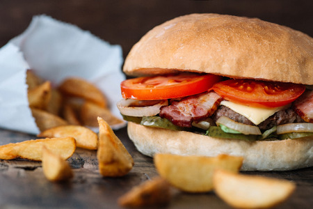 fresh tasty burger and fries on wooden tableの写真素材