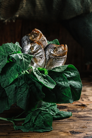 Still life with smoked fish and spinach on dark wood backgroundの写真素材