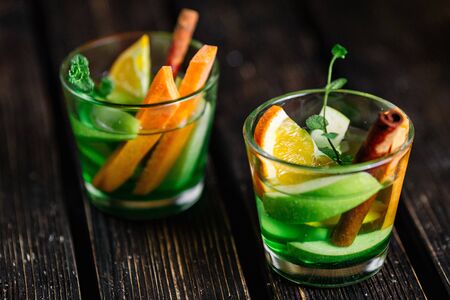 Two glasses of homemade lemonade with fresh fruits on wood backgroundの写真素材