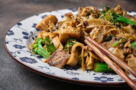 Delicious udon noodles with  beef  and brocolli on dark backgroundの写真素材