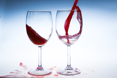 Splash red wine glass against a white backgroundの写真素材