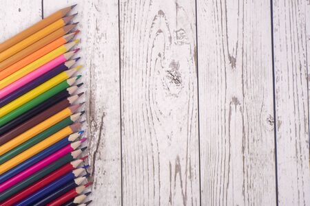 colorful pencils, markers and pens composition mock-up Back to school concept with stationery office supplies on a brown wooden background with copy space top viewの写真素材