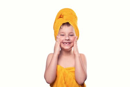 A boy without one tooth with cream on his face and in a towelの写真素材