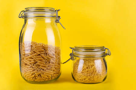 pasta in a glass jar on a yellow background