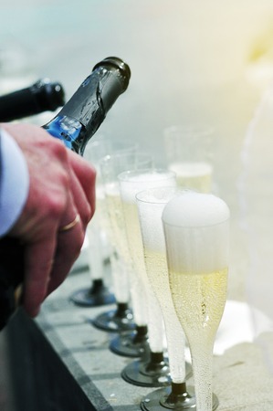 Pouring champagne into a glass on a wedding celebrationの写真素材