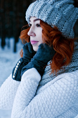 Young fashion girl red head in winter forestの写真素材