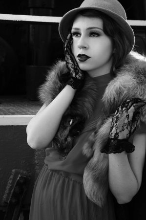 Beautiful fashion woman in retro clothes with locomotive on railway station platformの写真素材