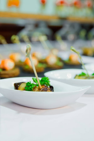 Catering eggplant rolled with cheese in white saucerの写真素材