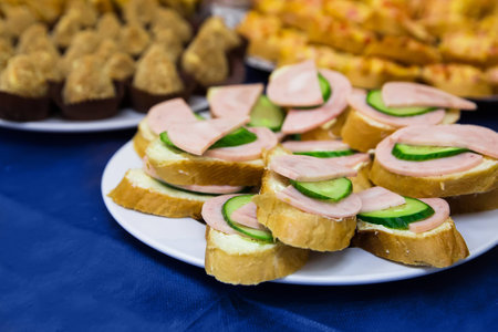 Sandwich with sausage and cucumber on blue tableの写真素材