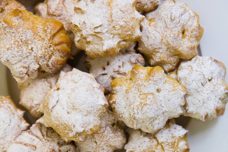 Cream puffs filled with pastry cream and sprinkled with powdered sugar catering on blue table