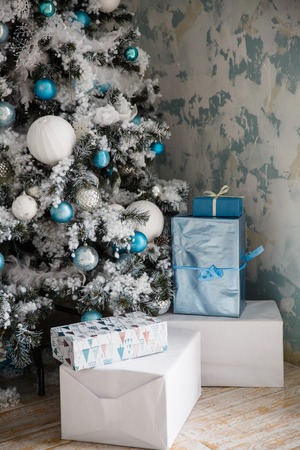 Christmas gifts under the Christmas tree with decorations in the morning, the interior in vintage styleの写真素材
