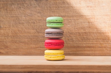 Four colorful tasty french macarons isolated on wood textureの写真素材
