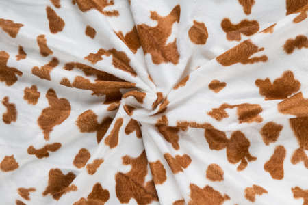 Colored brown textile satin fabric folded in folds and waves with highlights and texture shimmers in the lightの写真素材