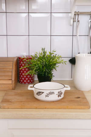 White empty ceramic baking dish in a light scandinavian kitchen in the morning