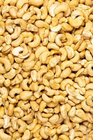 Peeled fresh golden cashew nuts in bulk top view for backgroundの写真素材