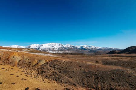 High cliffs in the mountains with snow on the peaks in Altai in autumnの写真素材