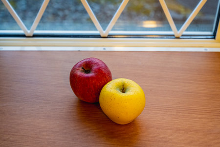 Japanese yellow and red apples on table close-upの写真素材