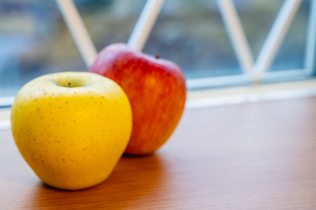 Yellow and red apples on table close-upの写真素材