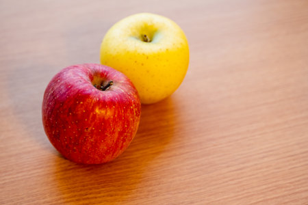 Japanese yellow and red apples on table close-upの写真素材