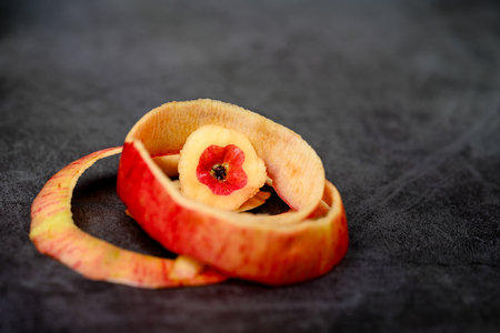 There is no skin on the apple pulp, and the remaining apple skin is a hollow apple with black backgroundの写真素材