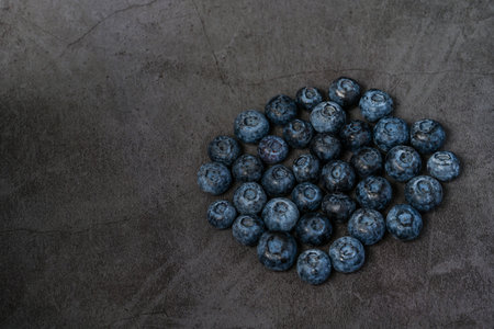 Close-up of blueberries on dark background.Fresh Blueberry Bounty. Close-up of ripe juicy...