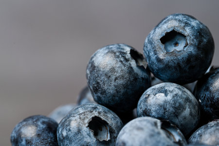 Close-up of blueberries on dark background.Fresh Blueberry Bounty. Close-up of ripe juicy blueberries filling the frameの写真素材