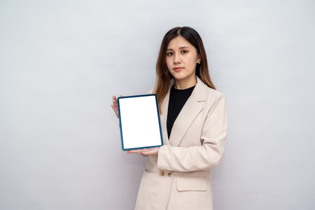 Woman Presenting Digital Tablet for Corporate Use,Professional Woman Holding a Blank Tablet for Marketing and Presentationの写真素材