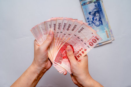 Holding New Taiwan Dollar, Taiwan banknote, symbol of wealth and successの写真素材