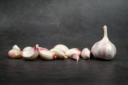Fresh Garlic Bulb with Peeling Skins. purple garlic. Suitable for cooking, health, food introduction, nutrition topics.の写真素材