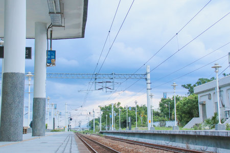 Taiwan May 21, 2024: A railway track curving into the distance beside a station platform, surrounded by greenery and power poles Fuli Station and Train in Taiwanの写真素材