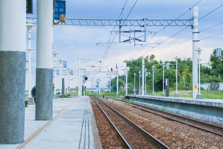Taiwan May 21, 2024: A railway track curving into the distance beside a station platform, surrounded by greenery and power poles Fuli Station and Train in Taiwanの写真素材