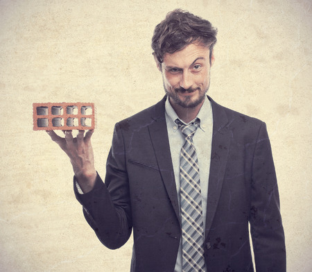 young crazy businessman with a brickの写真素材