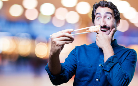 young man eating sushiの写真素材