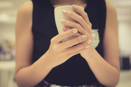 Woman hands holding white cup of coffeeの写真素材