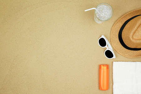 top view a hat , sunglasses ,shoes and water drink on sand beach.の写真素材
