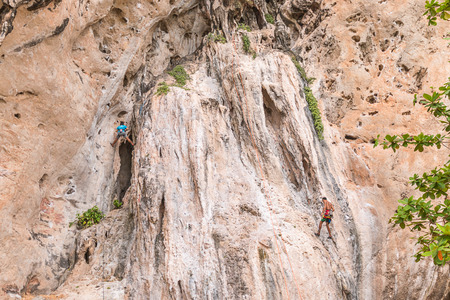RAILAY, THAILAND - May 4, 2016: Rock climbers climbing the wall on Railay beach, one of the most popular rock climbing locations in Asia.のeditorial素材