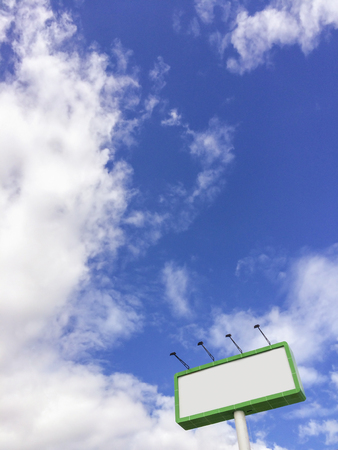 Billboard with empty screen, against blue cloudy skyの写真素材