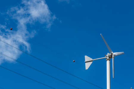 low angle view of wind turbine against partly cloudy blue skyの写真素材