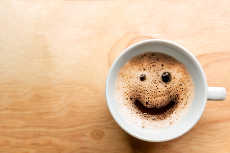froth milk foam smiles in a cup of coffee in morning.の写真素材